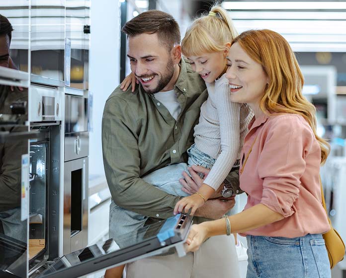 A young family of three checking out appliances at the department store