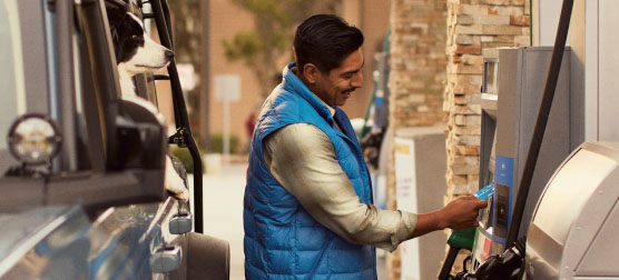 A man fills fuels up at a gas station