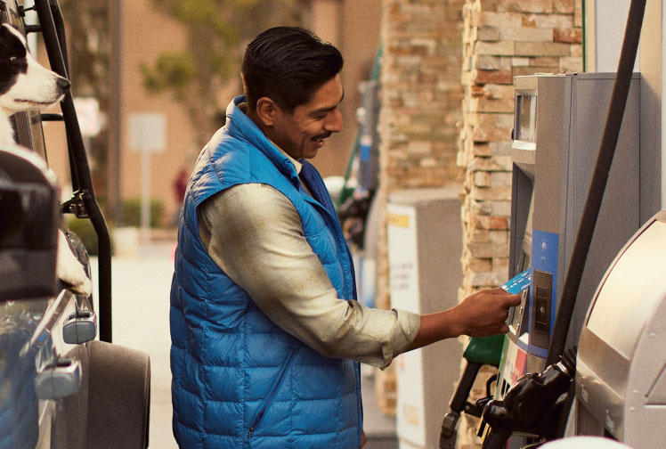 A man fills fuels up at a gas station
