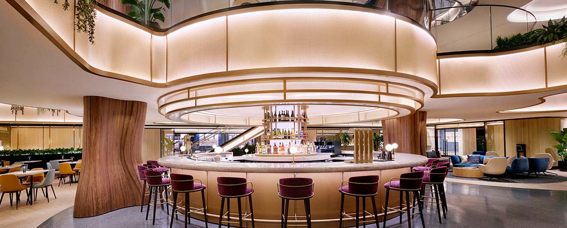 Sapphire Lounge at LaGuardia Airport, New York, with a circular bar counter, high stools, and warm lighting.