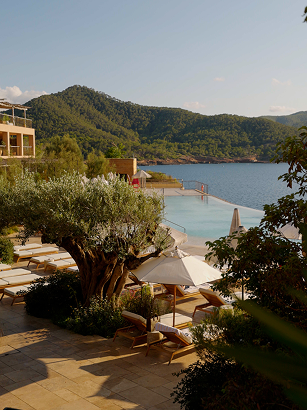 Luxury resort overlooking a turquoise bay surrounded by green hills