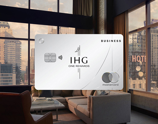 IHG One Rewards Premier Business credit card displayed in front of a modern hotel room with city views
